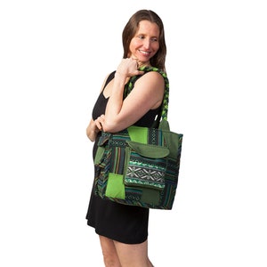 May include: A green and black patchwork tote bag with a green strap. The bag has a large pocket on the front and a smaller pocket on the side.