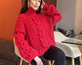 May include: A vibrant red cable-knit sweater featuring a high turtleneck collar, long sleeves with dropped shoulders, and a thick, textured weave pattern. The garment is paired with black leggings and black knee-high boots for a complete look.