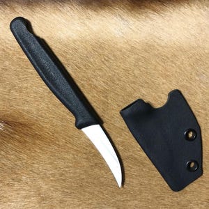 May include: A black paring knife with a white blade and a black plastic sheath.