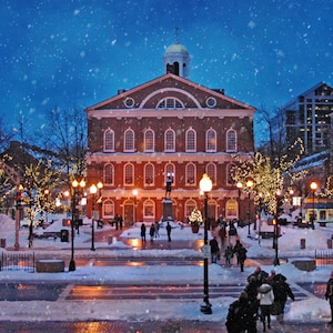 May include: A red brick building with a white trim and a dome on top. The building is decorated with Christmas lights and there is snow falling in the background.