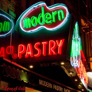 May include: A neon sign for a bakery called "Modern Pastry" with red and green lettering. The sign is lit up and the letters are outlined in white.