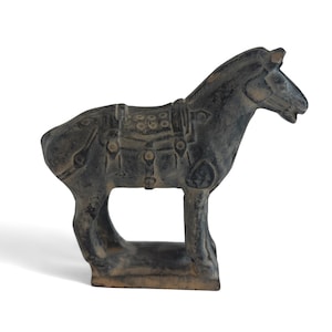 May include: A dark gray, weathered-looking horse figurine with a saddle. The horse is standing on a rectangular base. The figurine has detailed features and a textured surface, suggesting an antique or vintage style.