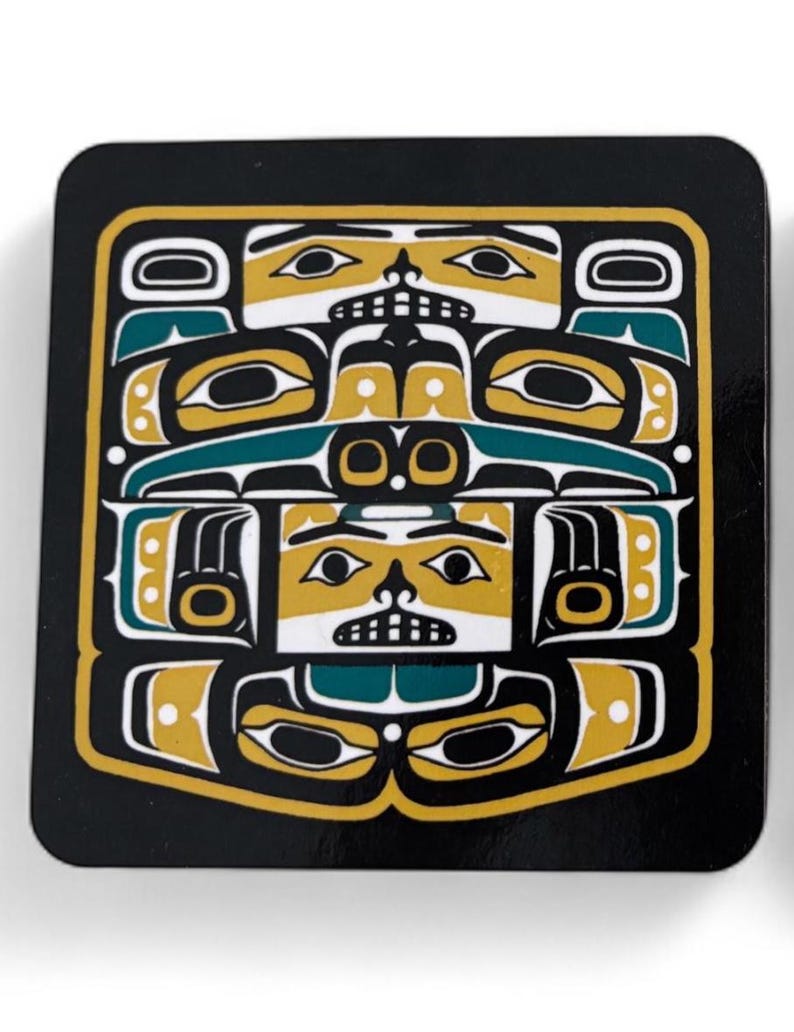 Puede incluir: Posavasos cuadrado con un dise&ntilde;o nativo americano. El posavasos presenta un fondo negro con un patr&oacute;n geom&eacute;trico amarillo y verde azulado. El dise&ntilde;o incluye caras y formas estilizadas, creando un aspecto audaz y art&iacute;stico. El posavasos probablemente est&aacute; hecho de un material duradero.