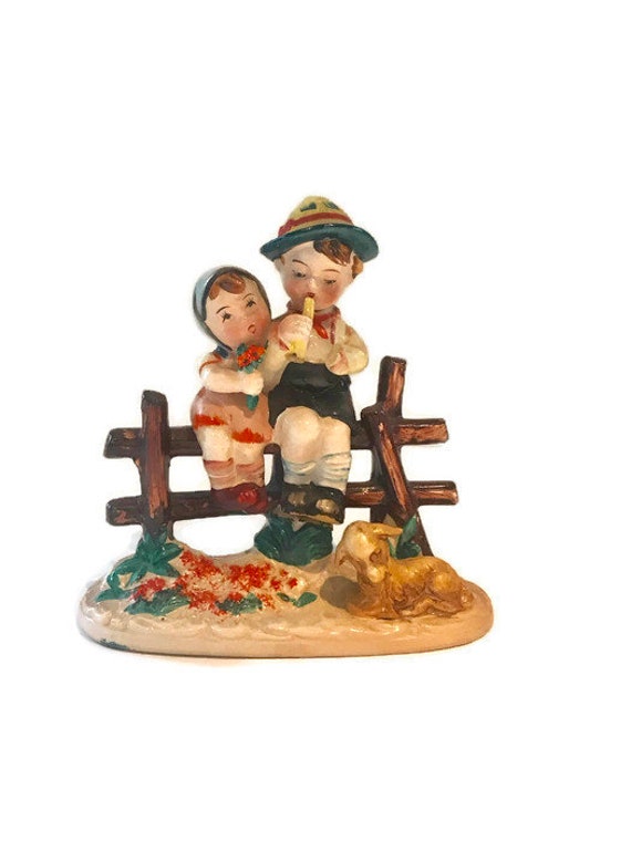 hummel boy sitting on fence