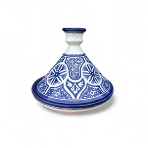 Op de afbeelding: Een blauw-witte keramische tajinepot met een conisch deksel en een ronde basis. De pot heeft ingewikkelde blauwe patronen en ontwerpen. De tajine is een traditioneel kookvat dat in de Noord-Afrikaanse keuken wordt gebruikt.