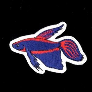 Peut inclure: Patch brodé représentant un poisson bleu et rouge avec un contour blanc.