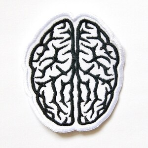 May include: An embroidered patch featuring a stylized human brain design. The patch has a white background with thick, black thread stitching forming the intricate, branching sulci and gyri patterns of the brain, finished with a white border.