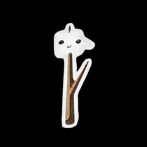 May include: Embroidered patch featuring a smiling marshmallow on a stick. The marshmallow is white with black eyes and a curved mouth. The stick is brown with a lighter brown branch. The patch has a white border against a black background.