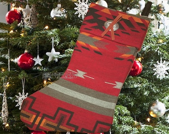 May include: Red and green Christmas stocking with a southwestern pattern and a silver button with a brown leather strap.