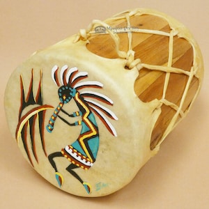 May include: A small, hand-painted Native American drum with a wooden frame and a leather head. The drum is decorated with a colorful Kachina figure and a black and red design. The drum is tied with a leather strap.