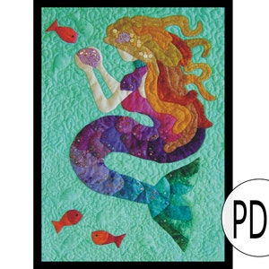 May include: A colorful mermaid quilt pattern with a mermaid holding a pearl and surrounded by red fish. The quilt is on a turquoise background.