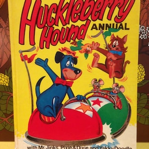 May include: A vintage Huckleberry Hound Annual book with a yellow cover. The cover features cartoon illustrations of Huckleberry Hound, Mr. Jinks, Pixie & Dixie, and Yakky Doodle. The title is in large red letters.