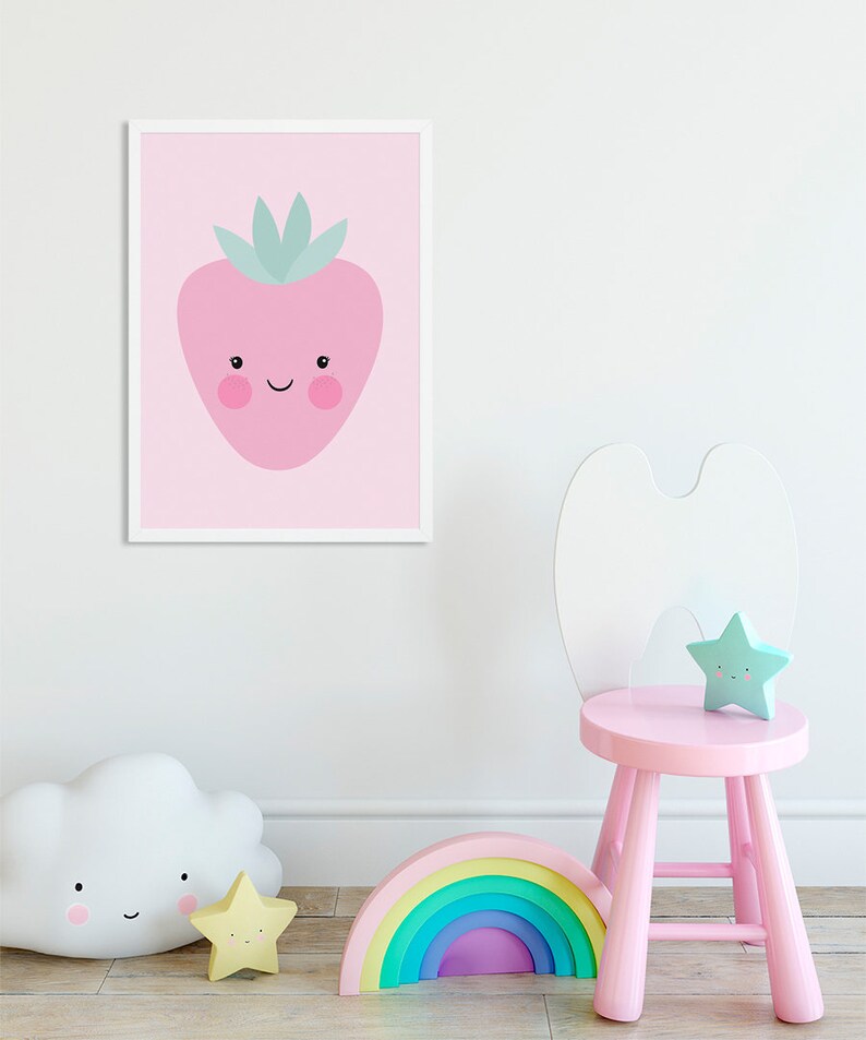 May include: A pink framed print of a cartoon strawberry with a smiling face on a pink background. A pink wooden stool with a white bunny ear back, a rainbow arch, a white cloud nightlight, and a yellow star nightlight are in the foreground.