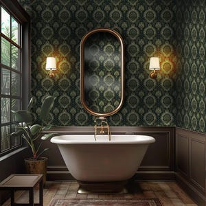 May include: A white freestanding bathtub with gold fixtures in a bathroom with dark green damask wallpaper, a gold oval mirror, and two gold wall sconces with white shades.