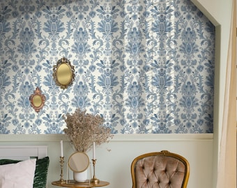 May include: A white and blue damask patterned wallpaper with a gold ornate frame mirror hanging on the wall. A small side table with a vase of dried flowers and candlesticks sits in front of a chair with a tufted back.