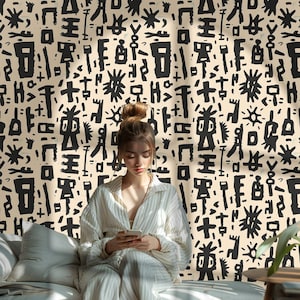 May include: A woman in a striped pajama set sits on a bed, using a smartphone. The background is a beige wallpaper with a repeating black abstract pattern. The room is lit by natural light.