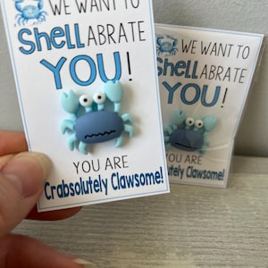 May include: Two blue and white cards with a blue crab illustration. The text on the cards reads "We want to Shellabrate You! You are Crabsolutely Clawsome!"