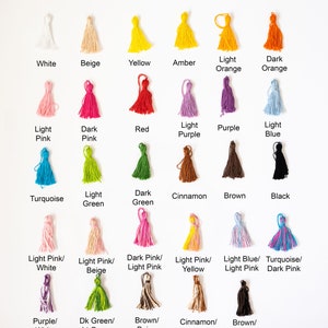 May include: A chart displaying 20 different colours of yarn tassels. The colours include white, beige, yellow, amber, light orange, dark orange, light pink, dark pink, red, light purple, purple, light blue, turquoise, light green, dark green, cinnamon, brown, black, light pink/white, light pink/beige, dark pink/light pink, light pink/yellow, light blue/light pink, turquoise/dark pink, purple/white, dark green/light green, brown/beige, cinnamon/beige, and brown/black.