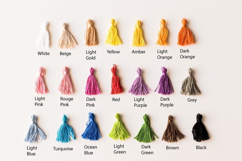 May include: A color chart of 18 different colors of yarn with tassels. The colors include white, beige, light gold, yellow, amber, light orange, dark orange, light pink, rouge pink, dark pink, red, light purple, dark purple, grey, light blue, turquoise, ocean blue, light green, dark green, brown, and black.