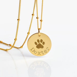 If you would like to use a custom image of your pet's pawprint, please choose one of the CUSTOM options from the first menu. Disc charm is 16 mm/ 0.5 in
Model is wearing 18 in length with gold satellite chain. name charm necklace, name necklace
