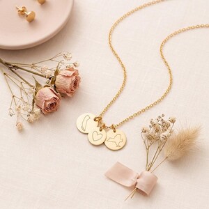Personalized two state necklace displayed on soft fabric with dried roses and ribbon.