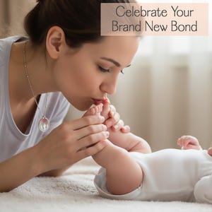 Custom baby footprint necklace with engraved footprints and personalized text. A heartfelt remembrance or memorial jewelry piece, offering comfort through a wearable tribute that keeps a baby’s memory close with a simple, elegant round pendant design.