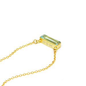 A gold set blue topaz adira bar necklace with the 12-9-94 engraved on the top. Creativity crystal jewelry, self expression necklace, self expression jewelry, custom name necklace, engraved bar necklace, personalized birthstone jewelry