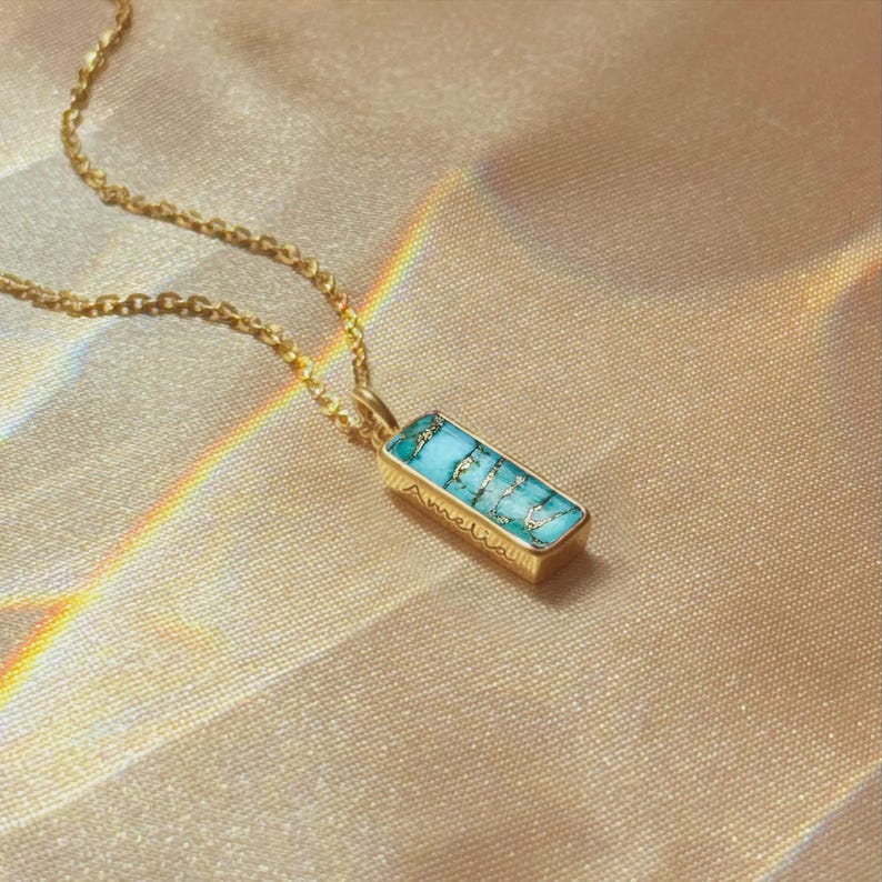 Natural copper turquoise baguette bar necklace worn on a gold chain, December birthstone pendant with hidden engraving option for a name, date, or word. A dainty and elegant jewelry gift for birthdays, anniversaries, or push present keepsakes for mom or wife.