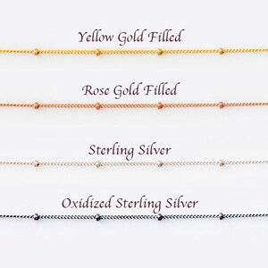 This image shows 4 satellite chains displaying the different metal options that we offer. The options are yellow gold, rose gold, sterling silver and oxidized (blackened) silver.