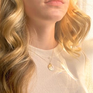 Model wearing sterling silver personalized footprint necklace on a satellite chain, engraved with actual baby footprints and child’s name. A minimalist yet meaningful keepsake for everyday wear, perfect as a new mom necklace, grandmother gift, or sympathy remembrance jewelry for families honoring a baby’s memory. Available in 925 sterling silver, 14K gold filled, or rose gold filled, with chain lengths from 16 to 30 inches Designed as a sentimental push present baby shower gift memorial heirloom