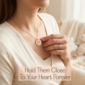 Custom engraved footprint necklace featuring a delicate chain and round pendant personalized with your baby’s real footprints, name, or date. A sentimental new mom gift, memorial keepsake, or meaningful piece of birth jewelry for everyday wear.