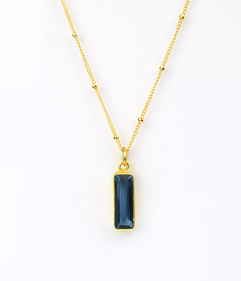 A vertical blue kyanite September birthstone Adira bar necklace on a gold satellite chain. Best friend jewelry, mom necklace, grandmother necklace, gift for aunt, gift for sister, nonbinary, gender neutral gift, Bat Mitzvahs, Sweet Sixteen parties