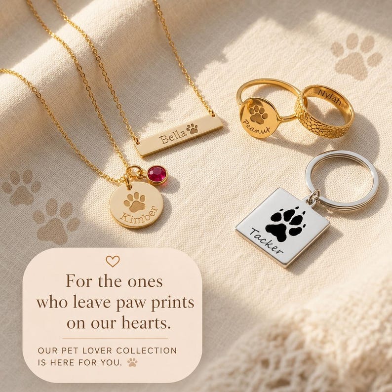 Personalized pet lover jewelry collection with engraved paw print necklaces, rings, and keychain on soft linen fabric.