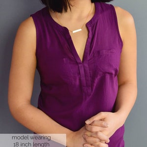 May include: A model wearing a purple sleeveless top with a gold bar necklace. The necklace is 18 inches long.  model wearing 18 inch length