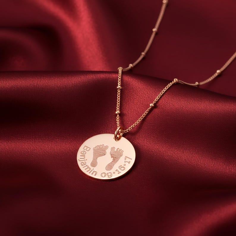 Round engraved baby footprint necklace featuring tiny footprints and optional name or birthdate. A sweet and meaningful new mom gift, this personalized pendant makes a beautiful keepsake to celebrate a baby’s first moments and cherish every milestone.
