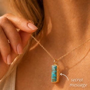 Close-up of turquoise pendant necklace with secret message engraving on the side of the gemstone bar.