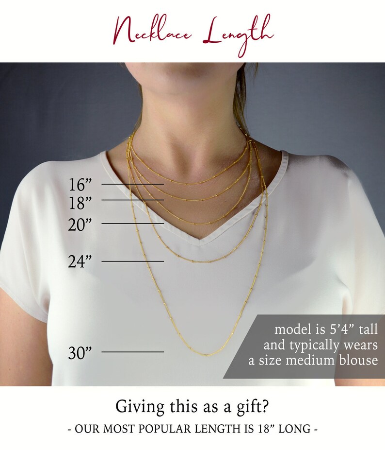 May include: A model wearing a white shirt with five gold necklaces of different lengths. The necklaces are labeled with measurements in inches: 16", 18", 20", 24", and 30". The text "Necklace Length" is at the top of the image. The text "model is 5'4" tall and typically wears a size medium blouse" is at the bottom of the image. The text "Giving this as a gift? - OUR MOST POPULAR LENGTH IS 18" LONG -" is at the bottom of the image.