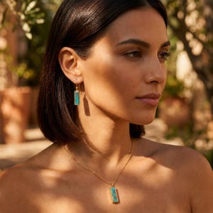 Turquoise December birthstone necklace and earrings styled on a model in warm natural light for everyday wear.