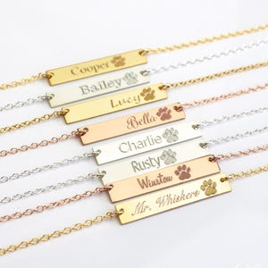 Custom engraved dog name bar necklaces in gold, silver, and rose gold with paw print engraving, personalized pet jewelry for multiple pets, pet adoption keepsake bracelet or necklace, custom pet nameplate gifts for dog moms and cat lovers, layered name bar jewelry with pet names like Cooper, Bailey, and Rusty, thoughtful gift for new pet owners, animal rescue volunteers, or pet adoption day celebration, minimalist and meaningful pet lover jewelry handcrafted with love.