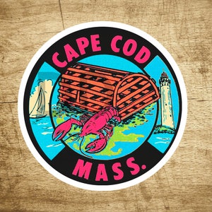 May include: A blue and black circular sticker with the text "CAPE COD MASS." in white. The sticker features a lobster, a lighthouse, and a lobster pot.