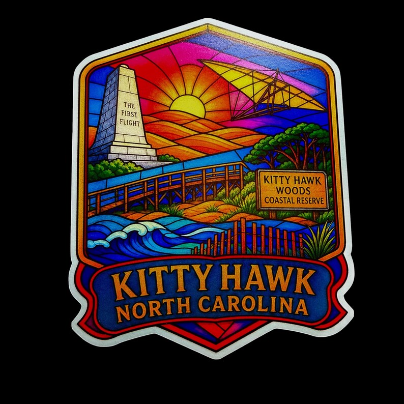May include: A colorful sticker featuring a stained-glass style illustration of Kitty Hawk, North Carolina. It depicts the Wright Brothers monument with the text THE FIRST FLIGHT, a glider, a wooden boardwalk, and a sign reading KITTY HAWK WOODS COASTAL RESERVE.