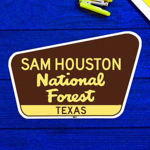 May include: A brown and yellow sign with the text "SAM HOUSTON National Forest TEXAS" in a retro style font.