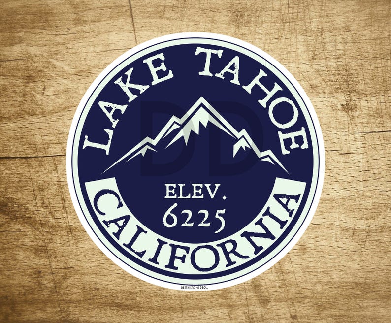 May include: A white circle sticker with a blue background and white text. The text reads "Lake Tahoe, Elev. 6225, California". The sticker features a stylized image of mountains.