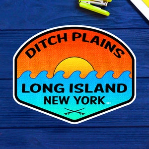 May include: A colorful sticker with a sunset and waves, reading "Ditch Plains Long Island New York" with a crossed paddle design.