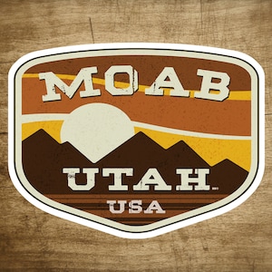 May include: A vintage-style logo with a brown, orange, and yellow color scheme. The logo features the text "MOAB UTAH USA" and a stylized image of a sunset over mountains.