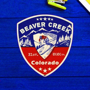 Peut inclure: Un emblème de station de ski de style vintage rouge, blanc et bleu avec le texte "Beaver Creek Colorado" et "Elev. 8080 ft."