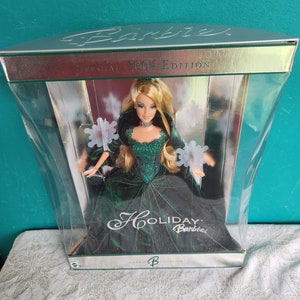 May include: 2004 Holiday Barbie Special Edition doll in a clear plastic display box. The doll wears a dark green velvet gown with a sparkly bodice. The box features silver accents and the text 'Barbie Special 2004 Edition' and 'Holiday Barbie'.