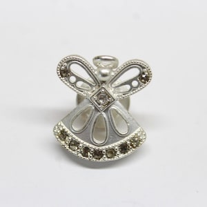 May include: A silver angel pin with clear and brown rhinestones. The angel has wings and a halo.