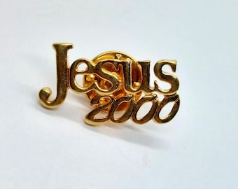 May include: Gold-colored pin with the words "Jesus 2000" in a stylized font.