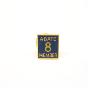 May include: Gold and blue square pin with the text "ABATE 8 MEMBER" on it.